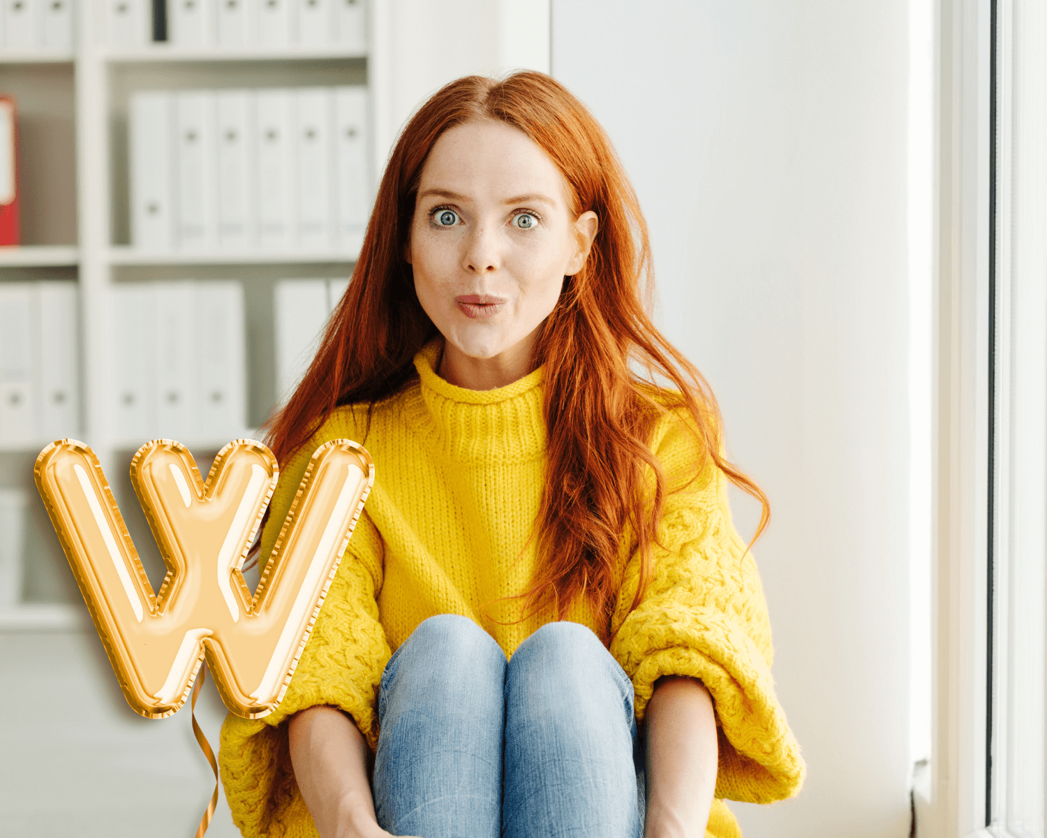 young woman wearing yellow sweater in front of W